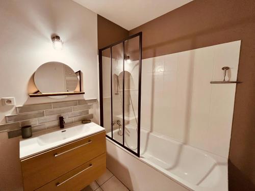 uma casa de banho com um chuveiro e um lavatório branco em T2 du centre, charme et exotisme em Saint-Jean-de-Monts