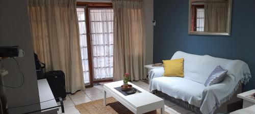 - un salon avec un canapé et une table dans l'établissement Rest and Rise, à Pietermaritzburg