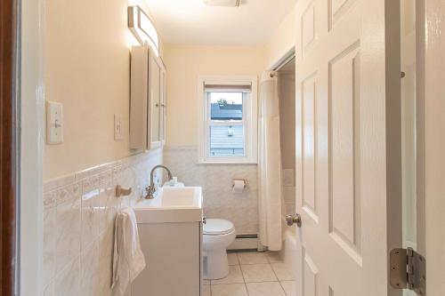 a bathroom with a sink and a toilet and a window at Pet-Friendly Cranston Home with Fire Pit and BBQ! in Cranston