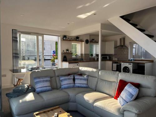 a living room with a gray couch with blue and red pillows at Beachfront retreat apartment with amazing terrace in Hastings
