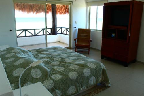 a bedroom with a bed and a view of the ocean at Villa Samotracia in Uaymitun