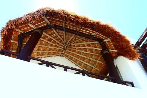 a building with a straw roof on top of it at Villa Samotracia in Uaymitun