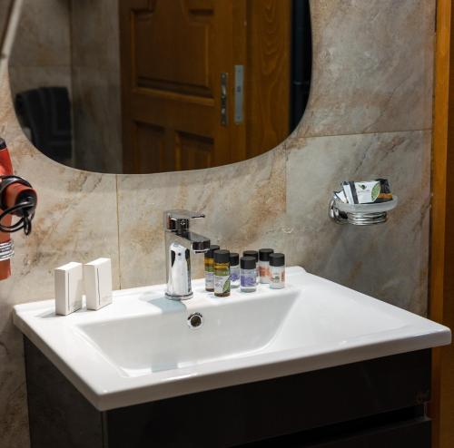 ein weißes Waschbecken im Bad mit Spiegel in der Unterkunft Black Suites in Chania