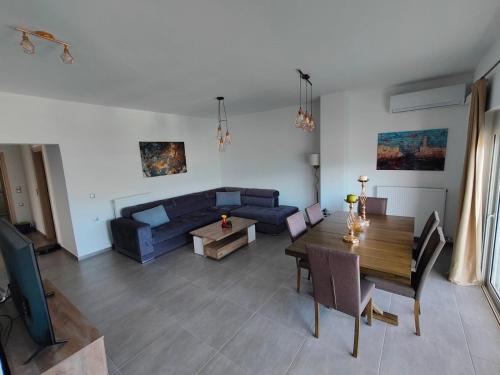 a living room with a blue couch and a table at ChrysPa, sea view apartment in Souda