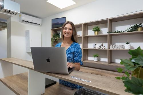 Eine Frau, die an einer Theke mit einem Laptop steht. in der Unterkunft Hostel Elli in Split