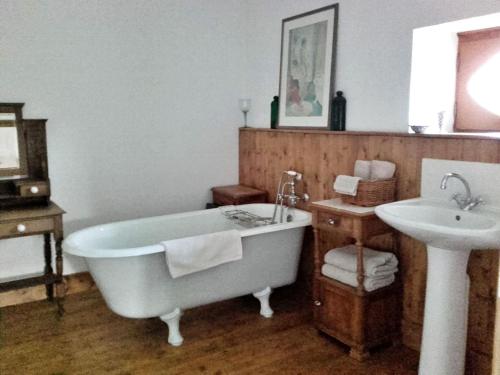 a bathroom with a bath tub and a sink at Gîte La Roche-Neuville, 6 pièces, 14 personnes - FR-1-600-148 in Loigné-sur-Mayenne