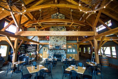 un restaurante con mesas y sillas y una chimenea en Heather Mountain Lodge, en Golden