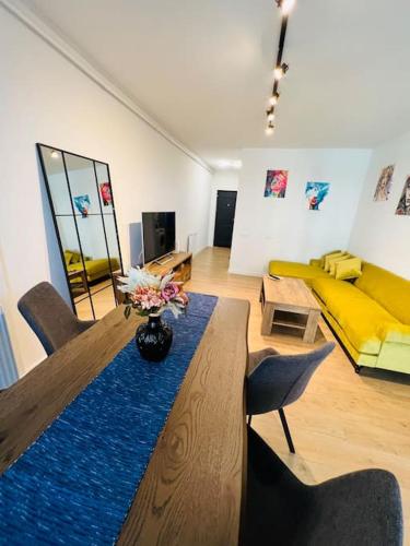 a living room with a table and a yellow couch at Apartament spațios zona buna in Cluj-Napoca