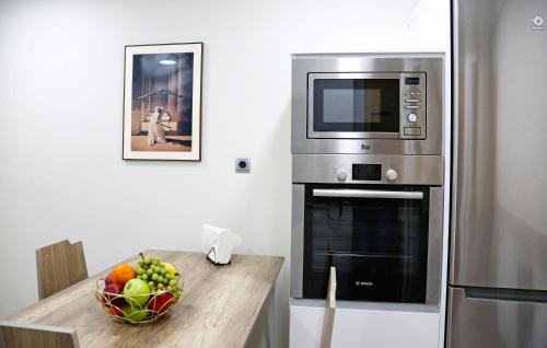 una cocina con una mesa con un bol de fruta y un microondas en River Deluxe con Garaje gratis, en Bilbao