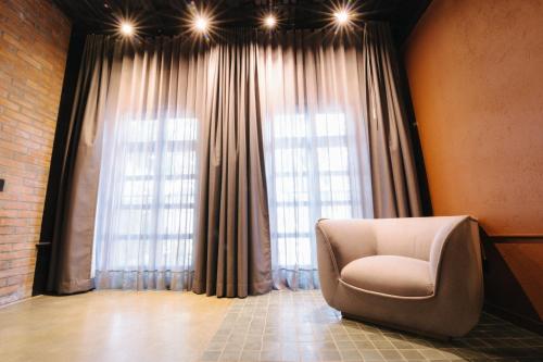 a chair sitting in front of a large window at The Art Hotel Medellin in Medellín