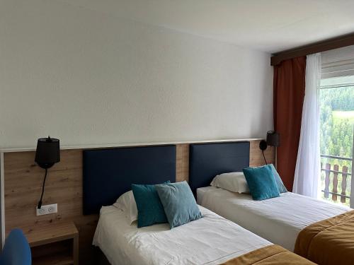 Ένα ή περισσότερα κρεβάτια σε δωμάτιο στο Hôtel Le Blainon