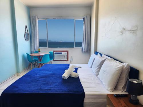 a bedroom with a blue bed with a teddy bear on it at Apto com Vista total da Praia de Copacabana TC802 in Rio de Janeiro