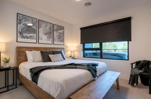 a bedroom with a large bed and a window at Ghost Peak by Revelstoke Vacations in Revelstoke