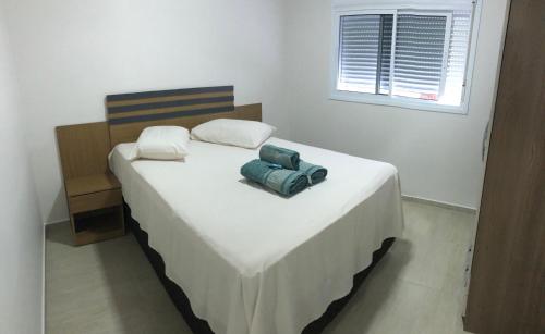 a bedroom with a large white bed with two pillows at Casa térrea para família no centro de Ametista! in Ametista do Sul