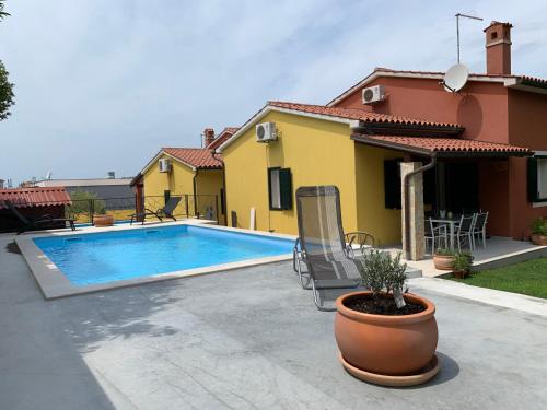 ein Haus mit einem Swimmingpool im Hof in der Unterkunft KAMENJAK VOLME, Cousy house with Pool in Banjole
