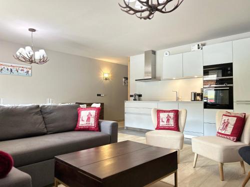 un salon avec un canapé et une table et une cuisine dans l'établissement Appartement neuf aux Gets, au pied des pistes et du centre, avec terrasse et services inclus - FR-1-623-50, aux Gets