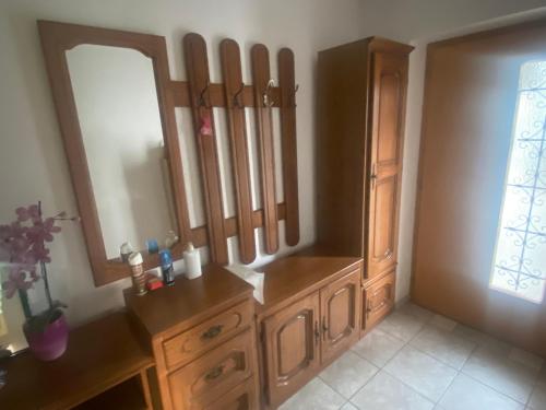 a bathroom with a wooden dresser and a mirror at Apartment GREEN HOUSE in Šempas