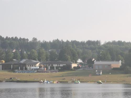 a group of people sitting on the shore of a lake at Gartenwohnung Paulsdorf in Dippoldiswalde