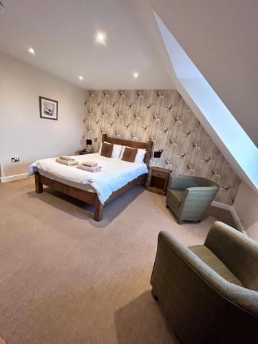 a bedroom with a large bed and a staircase at The White Hart Inn in Alfreton