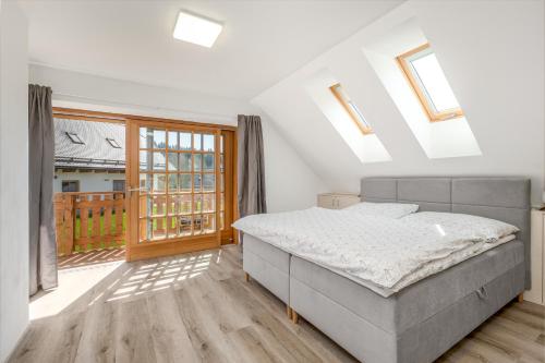a bedroom with a bed and a balcony at Chalupa ODDECH in Lipno nad Vltavou