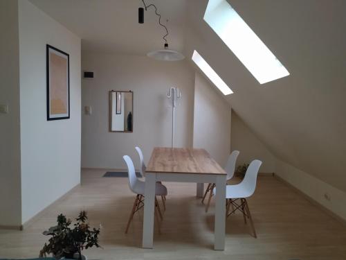 a dining room with a table and white chairs at Altavista mountain apartment in Samokov