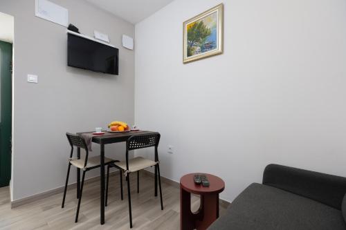 ein Wohnzimmer mit einem Tisch, Stühlen und einem Sofa in der Unterkunft Apartment Tanja Oldtown in Split