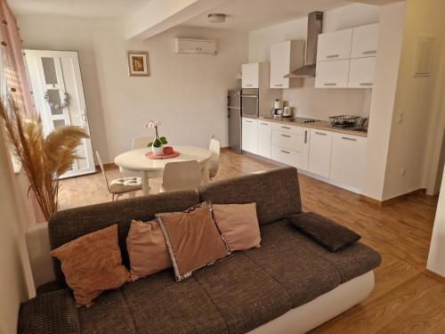 ein Wohnzimmer mit einem Sofa und einer Küche in der Unterkunft Apartment Dome in Biograd na Moru