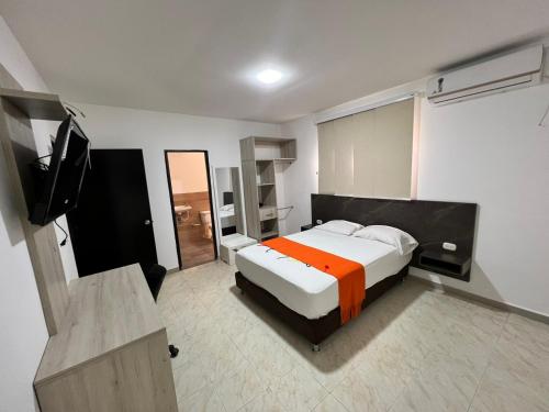 a bedroom with a bed and a flat screen tv at Hotel Villa Maria Uribia in Uribia