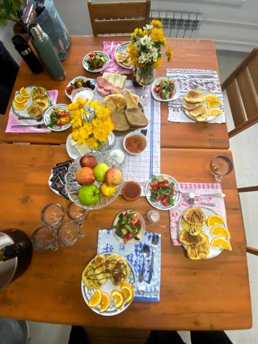 een houten tafel met borden met eten erop bij Altay Village Hotel in Ornok