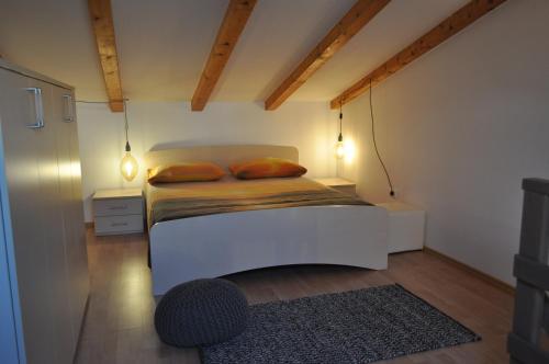ein kleines Schlafzimmer mit einem weißen Bett mit zwei Kissen in der Unterkunft KAMENJAK VOLME, Cousy house with Pool in Banjole