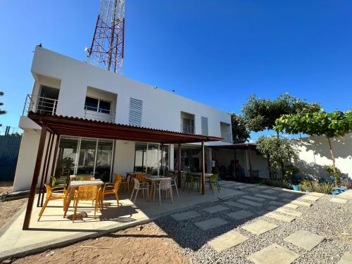 una casa blanca con mesas y sillas frente a ella en Hotel Villa Maria Uribia, en Uribia