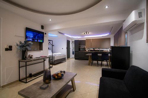 a living room with a couch a table and a kitchen at Black Suites in Chania