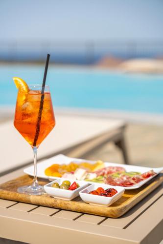 a tray of food and a drink on a table at Kirani Resort in Pantelleria