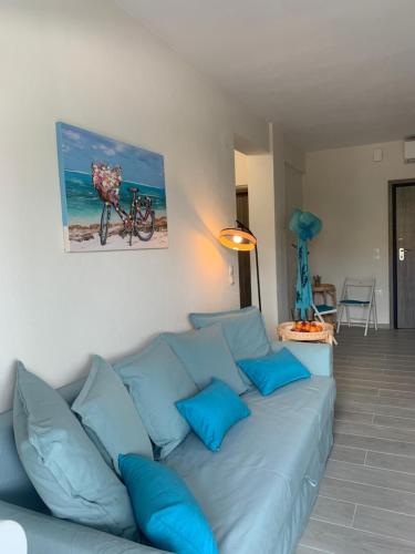 a blue couch in a living room with a bike on the wall at Blue Lagoon in Nikiti