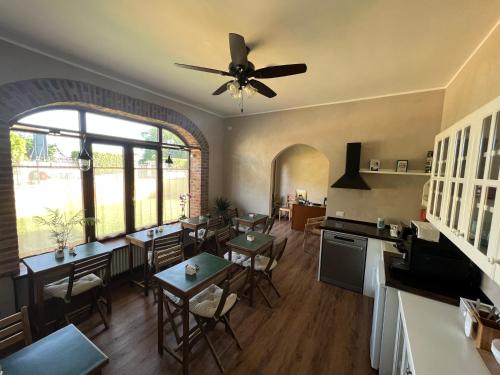 a kitchen with tables and chairs and a ceiling fan at Guest House Le Vagabonde in Fiumicino