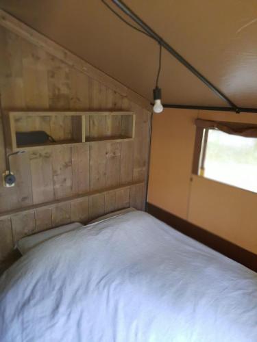 a bedroom with a white bed in a trailer at Safaritent Sarek, Wolvenspoor 10 in Vledder