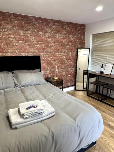 a bedroom with a large bed with towels on it at Perfect stay with Dallas Studio in Hayes