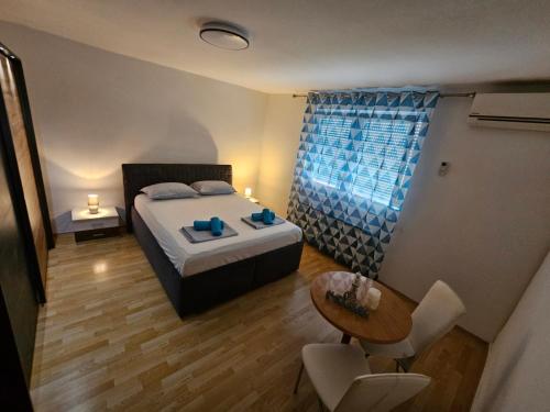 - une chambre avec un lit, une table et une chaise dans l'établissement Apartma RELAX, à Bertoki