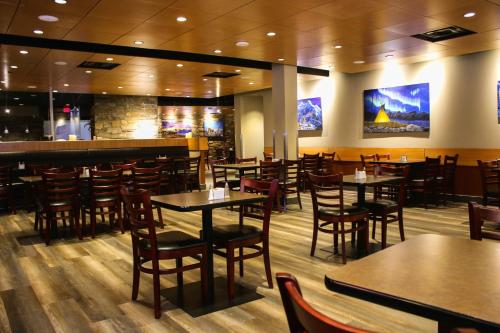 a restaurant with tables and chairs and a bar at Stoney Nakoda Resort & Casino in Seebe