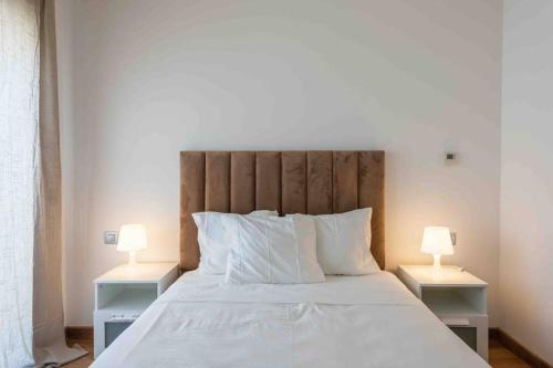 拉巴特Très bel appartement bien situé Hayriad的卧室里有一张白色的大床，床边还有两盏灯