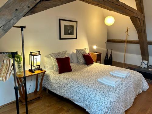 a bedroom with a bed and a table with a lamp at Maison Harmonie in La Châtre
