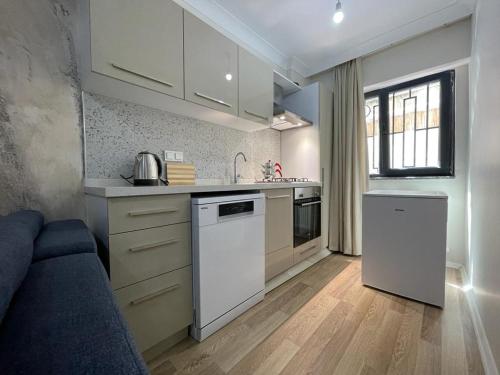 een keuken met witte apparatuur en een bank in de kamer bij Mina Suits in Istanbul