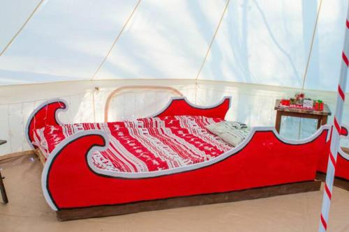 un letto rosso e bianco in una stanza di Candy Cane Glamp Yurt in the Woods a Columbia