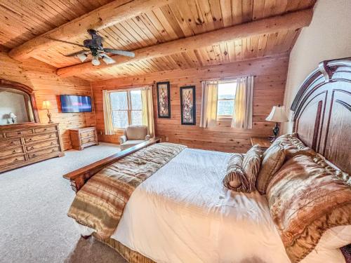 1 dormitorio con 1 cama grande y techo de madera en Lake Access Dock Hot Tub Fire Pit Game Room More, en Swanton