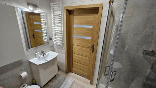 ein Bad mit einem WC, einem Waschbecken und einer Dusche in der Unterkunft Słoneczny Apartament Warka in Warka