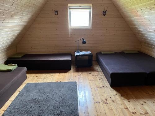 a attic room with two beds and a window at Domek na Żurawiej in Gdańsk