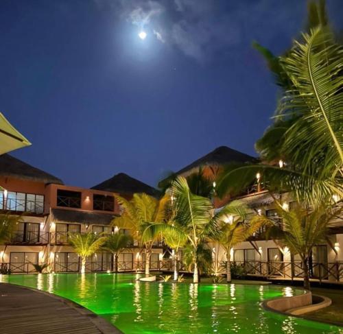 a resort with a green pool at night at Villas BobZ Apt.109 in Barra Grande