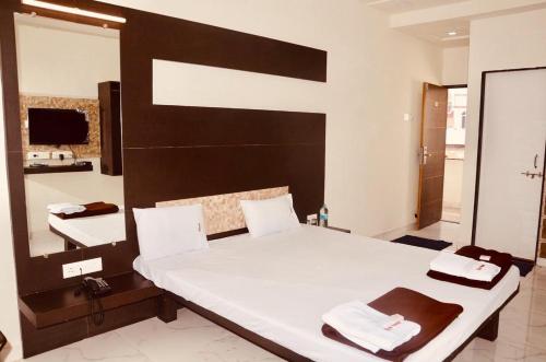 a bedroom with a large bed and a bathroom at Hotel Mangalam in Kurandvād