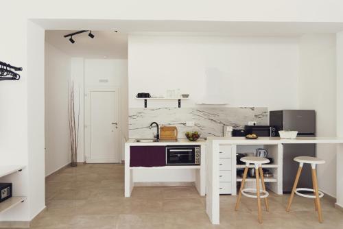 a kitchen with a sink and a counter with stools at Three Seasons in Kavos