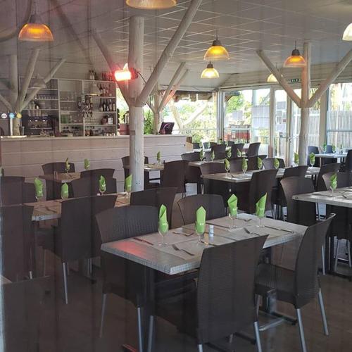 une salle à manger avec tables et chaises et un restaurant dans l'établissement MobilHome Aquitaine, à Gastes